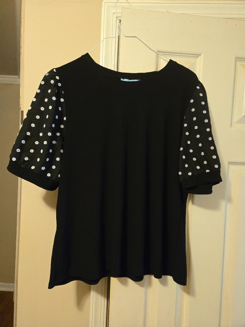 CeCe L black top with , white flowers on sleeves